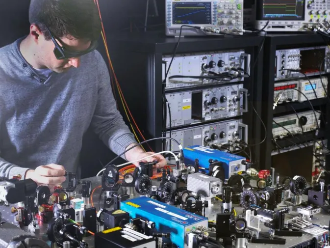 PTB scientist Johannes Thielking with the laser setup used for investigating the thorium-229 nucleus. (Photo: PTB)