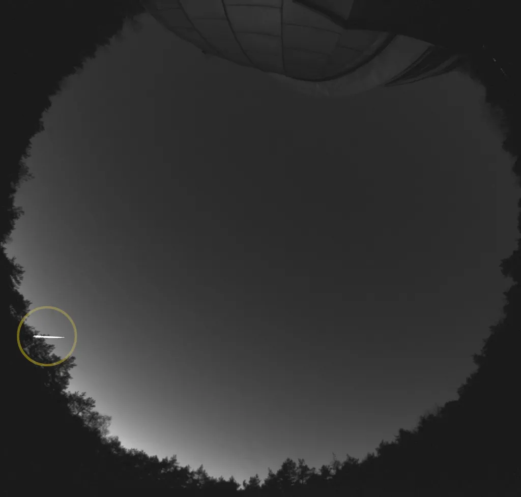 Bolid (zaznaczony kółkiem) zarejestrowany przez stację bolidową SN20 (OAUW Ostrowik k. Warszawy). W górnej części widać kopułę teleskopu. Fot. materiały prasowe