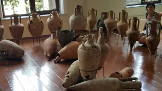 The author of the project surrounded by amphorae from the eastern part of the Mediterranean, Archaeological Museum in Batumi. Photo by M. Marciniak