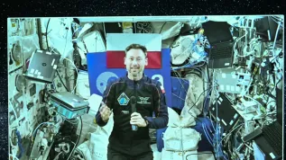 02.07.2025. Na ekranie przebywający na Międzynarodowej Stacji Kosmicznej polski astronauta Sławosz Uznański-Wiśniewski. PAP/Radek Pietruszka