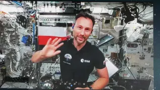 Sławosz Uznański-Wiśniewski (na ekranie) podczas połączenia wideo na żywo ze stacji ISS (jm) PAP/Marian Zubrzycki