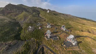 Widok z lotu ptaka na Obserwatorium Roque de los Muchachos na wyspie La Palma w Hiszpanii. W centralnej części zdjęcia widoczne są cztery teleskopy LST o średnicy reflektora 23 m. Na lewo od nich znajdują się dwa teleskopy MAGIC poprzedniej generacji, o średnicy reflektora 17 m. W sąsiedztwie teleskopów LST planowana jest budowa dziewięciu średnich teleskopów MST (Medium-Sized Telescopes), które wraz z teleskopami LST będą tworzyć północną stację Obserwatorium CTAO. (Źródło: LST Collaboration)