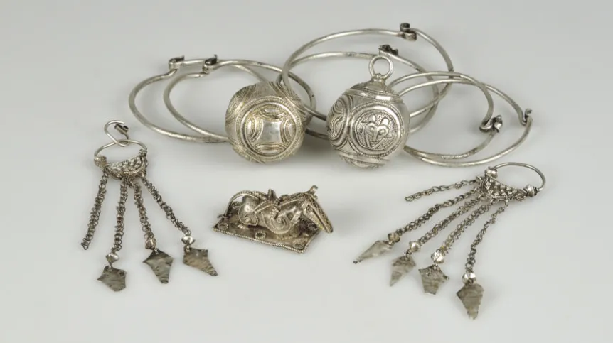 Srebrne zabytki z cmentarzyska Matzhausen. Sześć kabłączków skroniowych, dwie zausznice z zawieszkami na łańcuszkach, zoomorficzna ozdoba (okucie) w kształcie konia oraz zawieszki kuliste, Fot. materiały prasowe PMA 