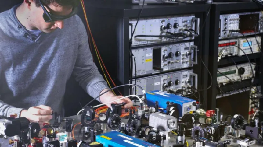 PTB scientist Johannes Thielking with the laser setup used for investigating the thorium-229 nucleus. (Photo: PTB)