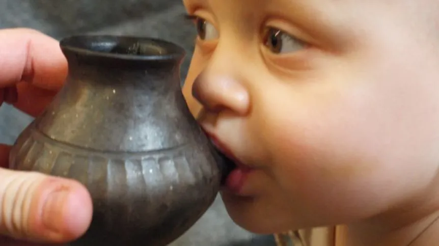 Dziecko karmione naczyniem podobnym do tych, które znaleźli archeolodzy, fot. Helena Seidl da Fonseca.