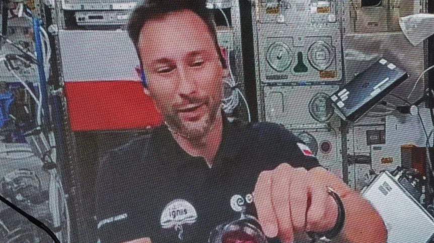 Łódź, 02.07.2025. Przebywający na Międzynarodowej Stacji Kosmicznej polski astronauta Sławosz Uznański-Wiśniewski (na ekranie) podczas połączenia wideo na żywo w EC1 w Łodzi. PAP/Marian Zubrzycki