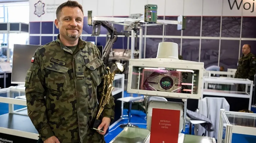 Płk dr hab. inż. Marek Życzkowski z Instytutu Optoelektroniki WAT. W rękach naukowca nagroda Defender. Obok - system SkanDron. Fot. WAT