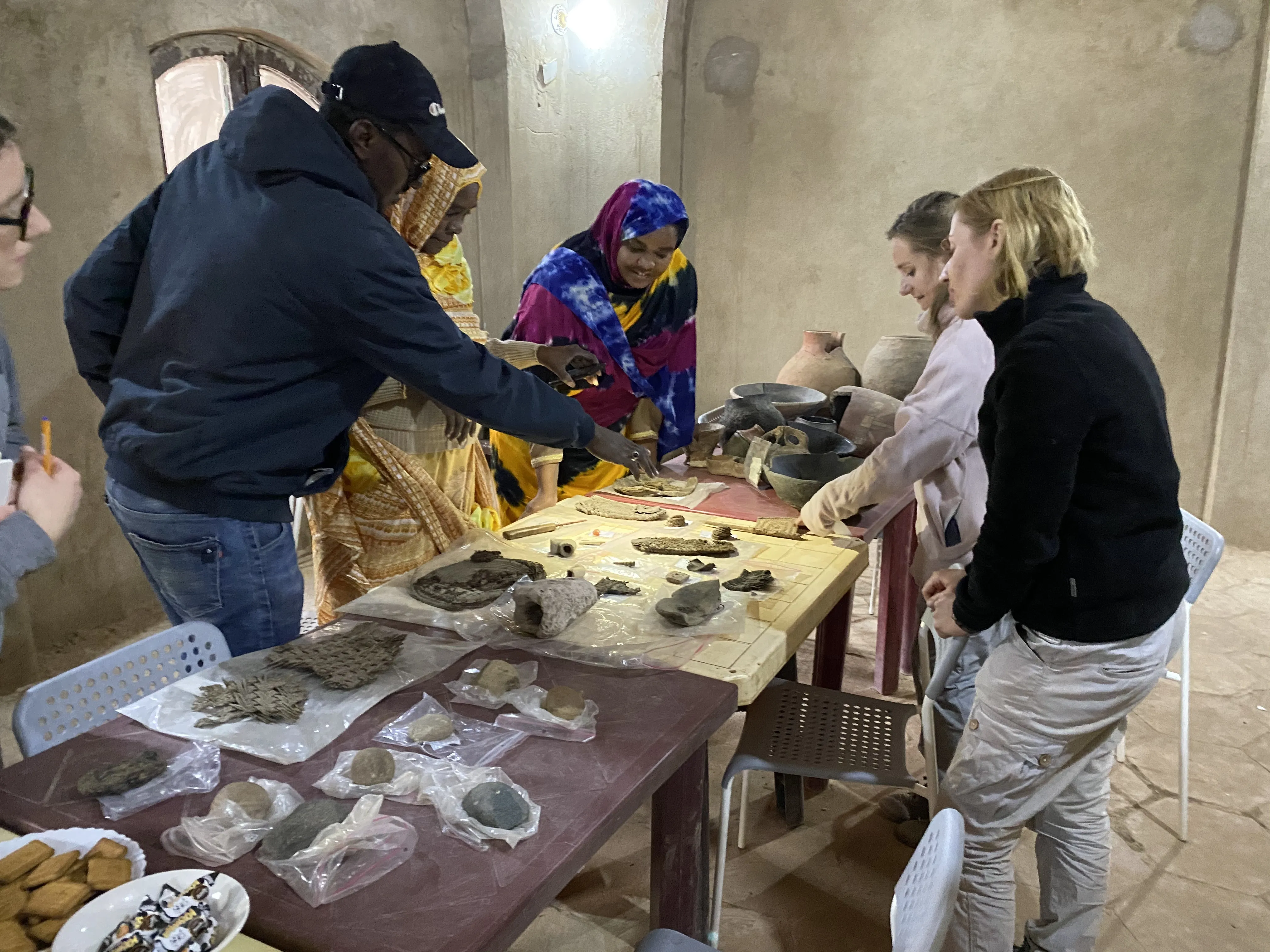 Polish archaeologists and local women try to identify excavated objects together. Credit: T. Fushiya