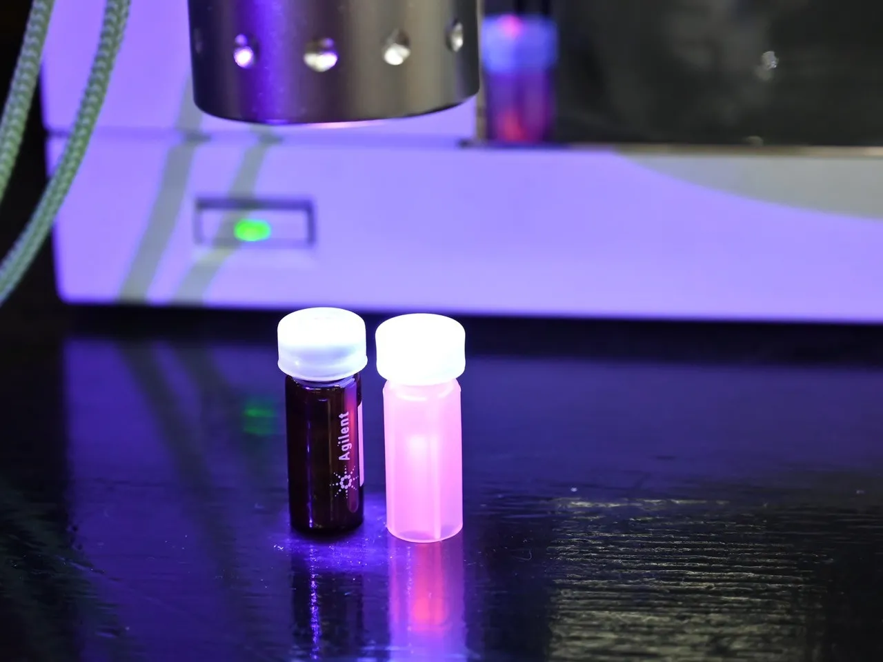 The glowing vial contains an aqueous dispersion of CdTe quantum dots modified with mercaptopropionic acid (CdTe/MPA), to which cisplatin can be attached via electrostatic interaction. Credit: Promotion Department of the Faculty of Chemistry, Warsaw University of Technology, Agnieszka Sikora
