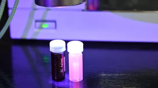 The glowing vial contains an aqueous dispersion of CdTe quantum dots modified with mercaptopropionic acid (CdTe/MPA), to which cisplatin can be attached via electrostatic interaction. Credit: Promotion Department of the Faculty of Chemistry, Warsaw University of Technology, Agnieszka Sikora